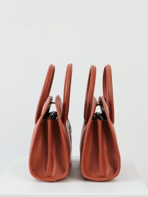 Stylish red leather handbags with a minimalist design, perfect for fashion enthusiasts.